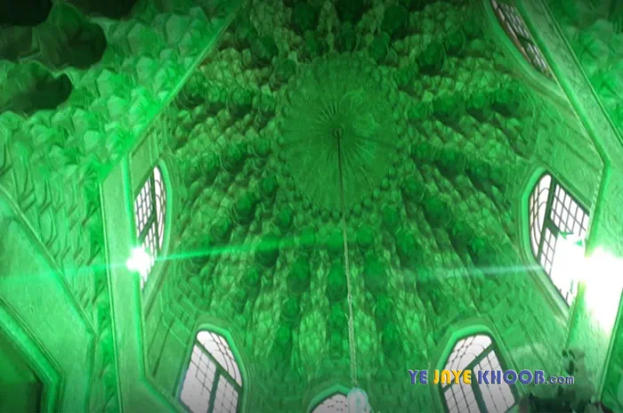 نمای معماری داخلی گنبد خشتی با چراغ های روشن به رنگ متبرک سبز